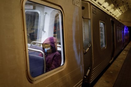 A passenger in a Washington Metro car wears a protective mask