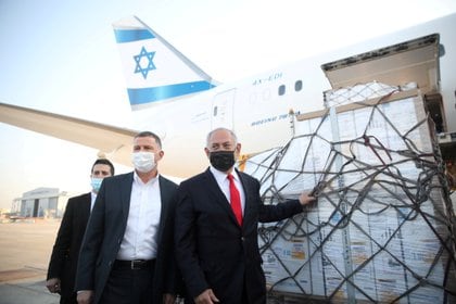 El primer ministro Benjamin Netanyahu y su ministro de Salud Yuli Edelstein reciben un cargamento de vacunas de Pfizer-BioNTech (Motti Millrod/Pool via REUTERS/Archivo)