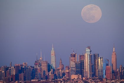 La luna llena de abril, llamada Super Pink Moon, se eleva sobre el horizonte de Manhattan, en la ciudad de Nueva York, el 26 de abril de 2021 (Photo by Angela Weiss / AFP)