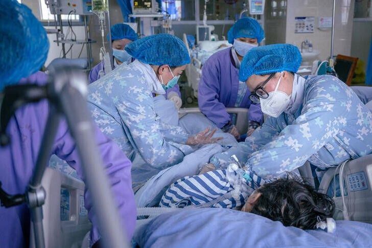 Trabajadores médicos atendiendo a un paciente de COVID en la unidad de cuidados intensivos del Hospital Popular del Distrito de Pengshan, en Meishan, provincia de Sichuan, China
