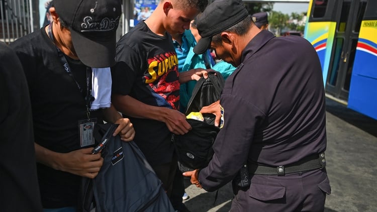 Oficiales de policías revisan mochilas durante uno de los operativos que se han vuelto habituales en los últimos meses en la capital salvadoreña.