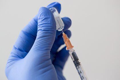 Trabajador médico extrae líquido con jeringa para aplicar uan vacuna (Bloomberg)