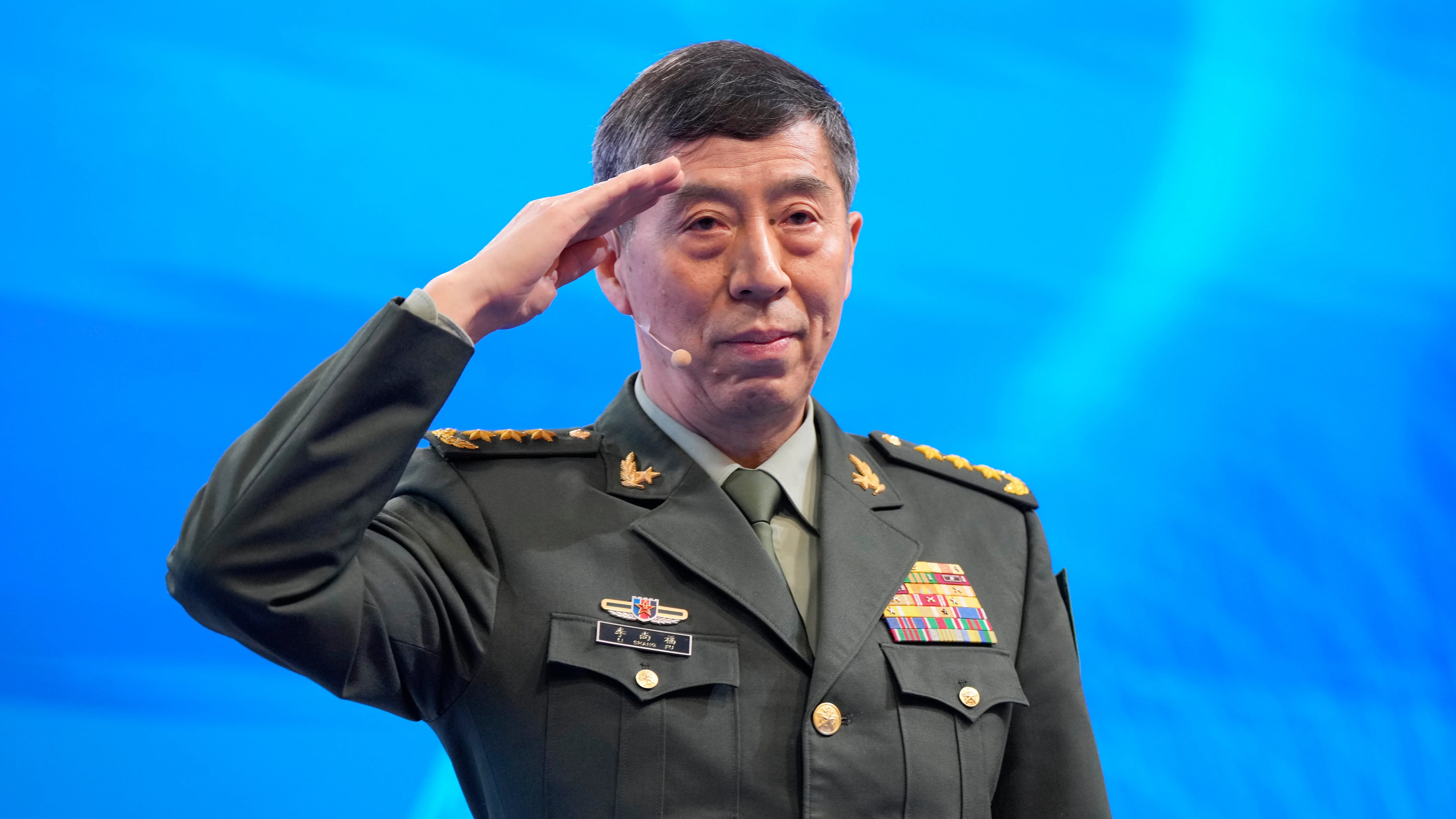 Chinese Defense Minister Li Shangfu salutes before delivering his speech on the last day of the 20th International Institute for Strategic Studies (IISS) Shangri-La Dialogue, Asia's annual defense and security forum, in Singapore, Sunday, June 4, 2023. (AP Photo/Vincent Thian)