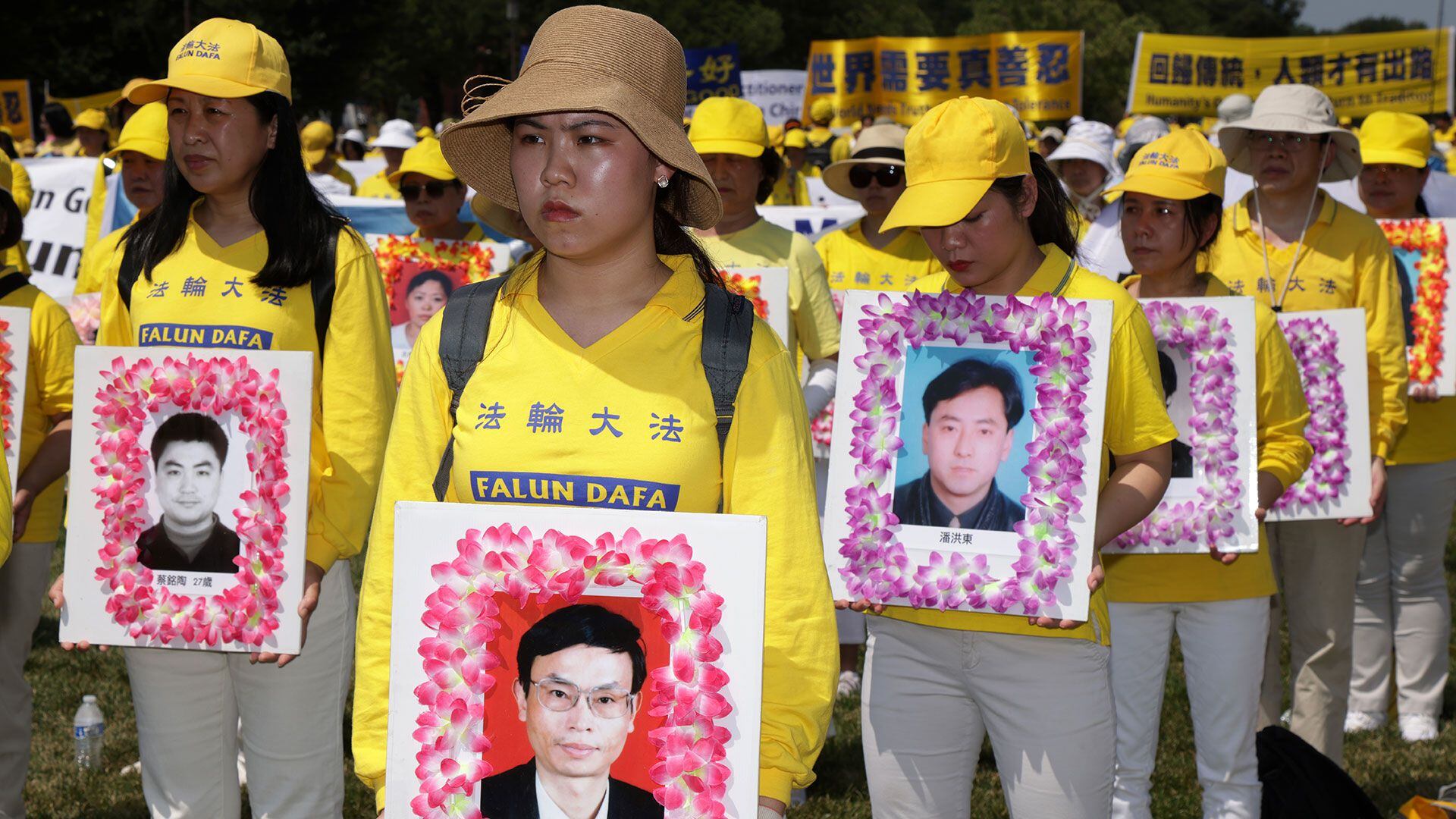 Practicantes de Falun Gong y simpatizantes sostienen fotos de víctimas que fueron perseguidas por el régimen chino mientras participan en una concentración y manifestación anual en el National Mall el 16 de julio de 2021 en Washington, DC (Foto de Alex Wong/Getty Images/Archivo)