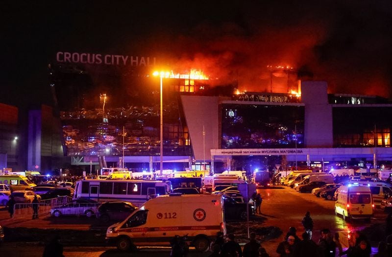 Ambulancias y vehículos de los servicios de emergencia rusos aparcan en la sala de conciertos Crocus City Hall en llamas tras un atentado, a las afueras de Moscú, Rusia, el 22 de marzo de 2024 (REUTERS/Yulia Morozova)