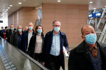 Peter Ben Embarek y otros miembros del equipo de la Organización Mundial de la Salud (OMS) encargado de investigar los orígenes de la enfermedad del coronavirus (COVID-19) llegan al aeropuerto internacional de Pudong en Shanghái, China. 10 de febrero de 2021. REUTERS/Aly Song