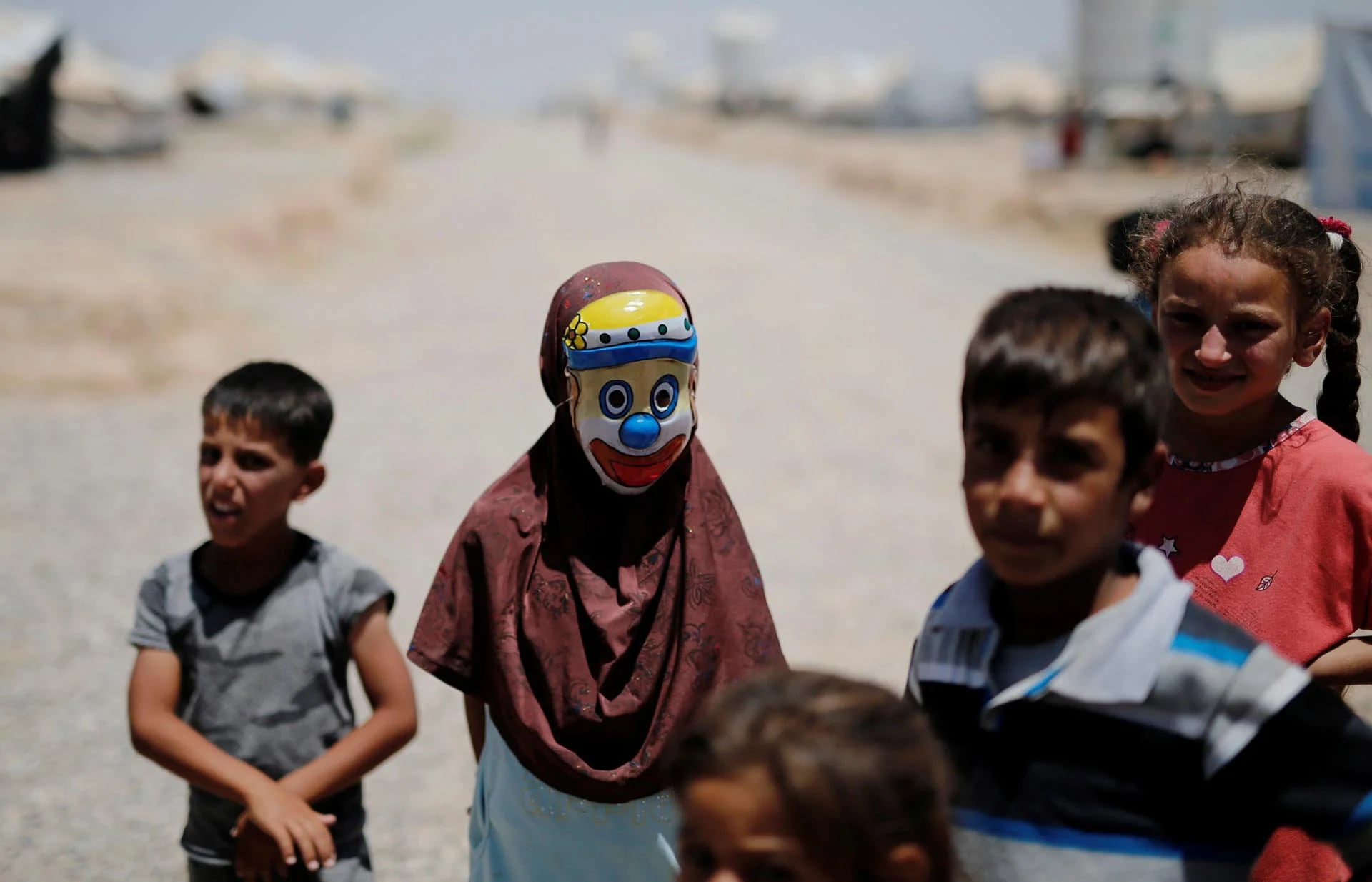 Una niña iraquí desplazada porta una máscara de payaso en el campamento de Hasansham en Al Khazer, al este de Mosul