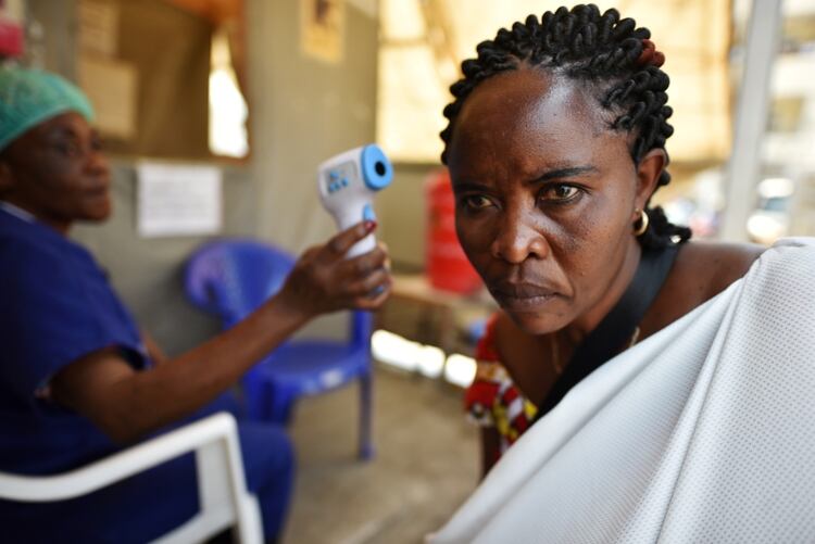 Una trabajadora médica toma la temperatura de una mujer en el Hospital General de Goma, en la República Democrática del Congo (REUTERS/Olivia Acland)