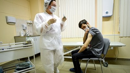 Una enfermera procede a inyectar a un joven con la vacuna Sputnik V en una clínica en Moscú. Los centros de vacunación están vacíos en Rusia por la desconfianza que despierta el desarrollo entre su población (AFP)
