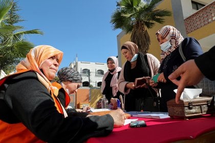 Palestinian women register their names for parliamentary and presidential elections, in a school in Gaza City February 10, 2021. REUTERS/Mohammed Salem