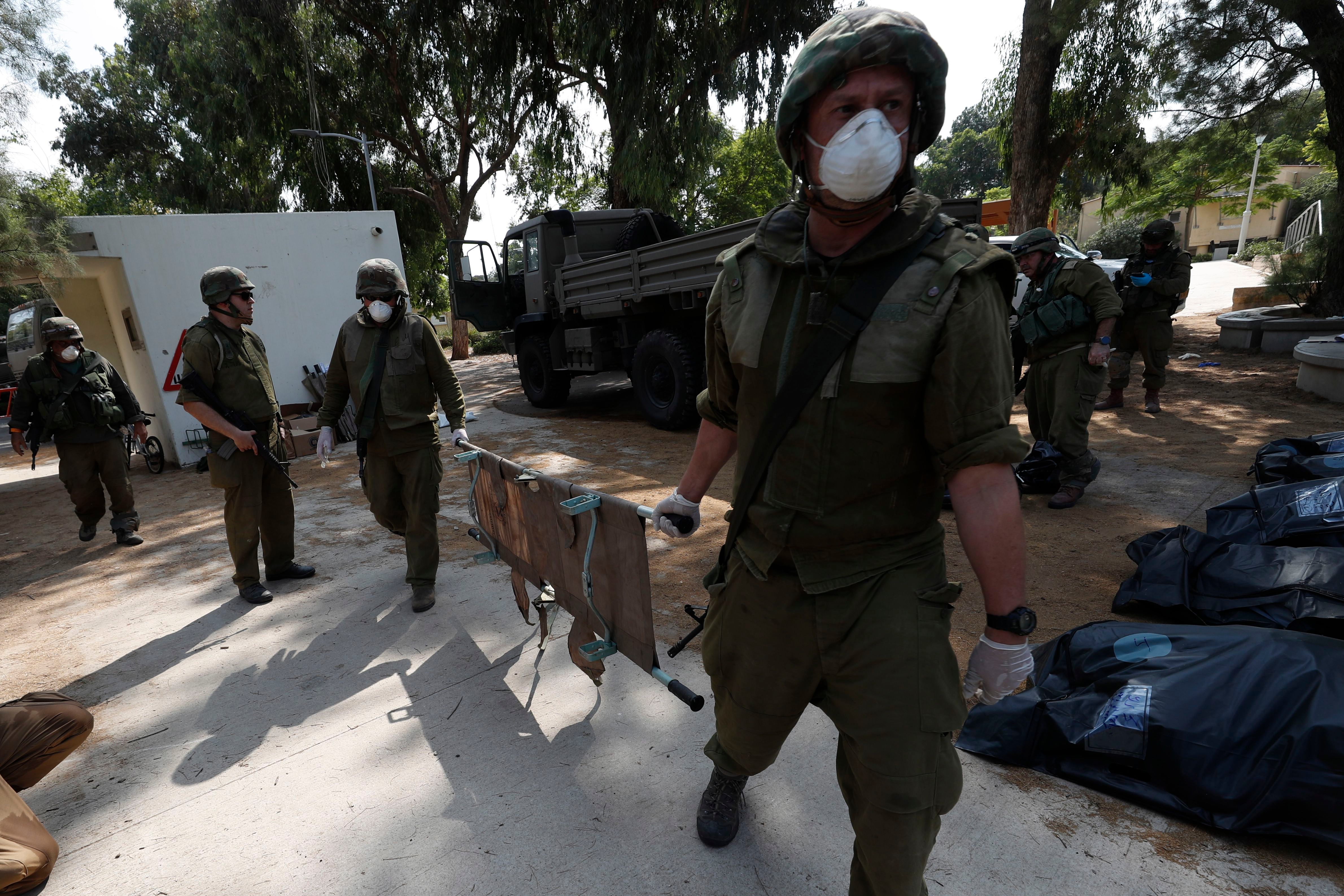 Soldados israelíes recogen los cuerpos de los israelíes asesinados en el kibutz de Kfar Aza, cerca de la frontera con Gaza, este 10 de octubre de 2023. EFE/EPA/Atef Safadi 