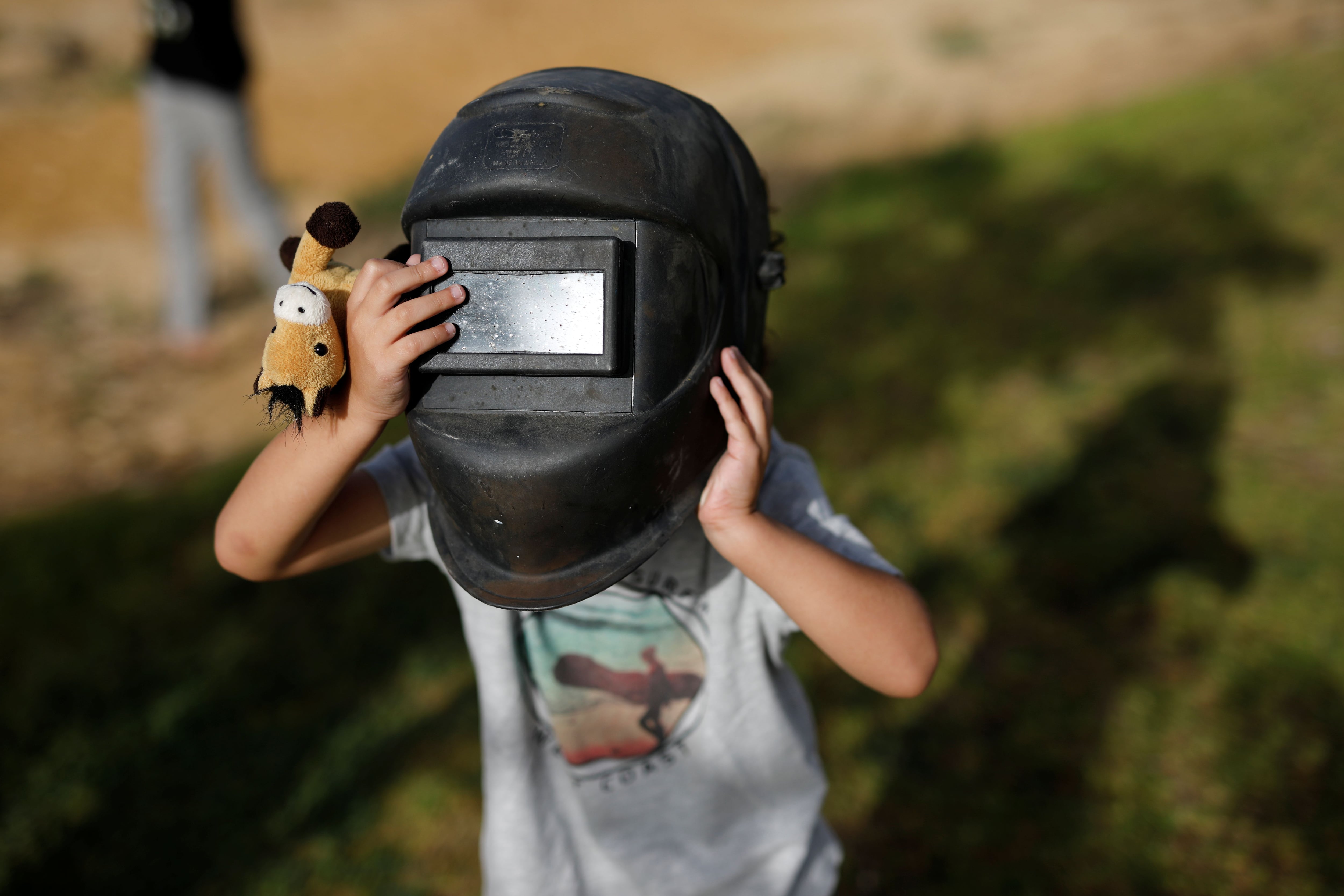 A boy wears a welding helmet as protection to observe a partial solar eclipse from Yeruham, southern Israel June 21, 2020. REUTERS/Amir Cohen