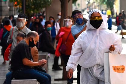 Un transeúnte viste un traje de alta seguridad sanitaria durante sus compras en el Centro histórico de Ciudad de México (Foto: EFE)