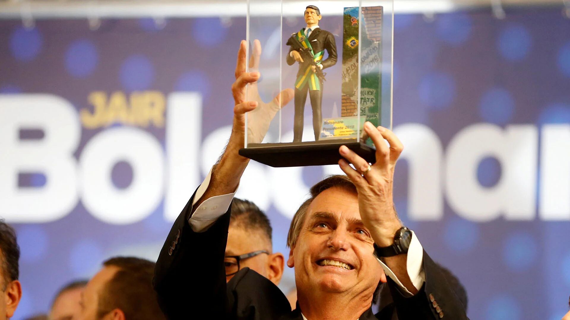 Jair Bolsonaro levanta un muñeco de él con la banda presidencial y sosteniendo un fusil de asalto, durante un acto en Curitiba (Reuters/ Rodolfo Buhrer)