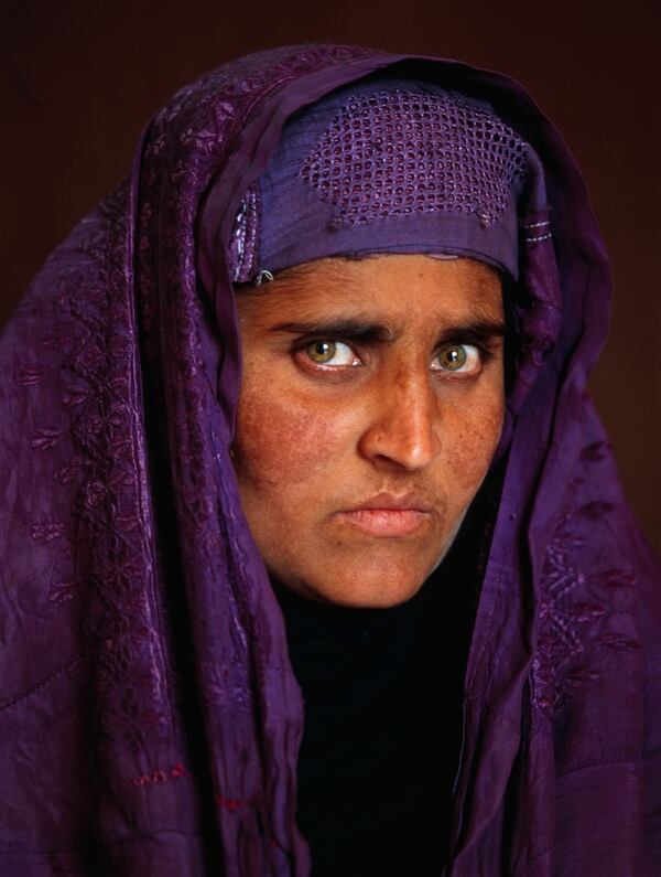 Dieciocho años después de su primera fotografía, Sharbat Gula, quien ahora vive en las montañas cercanas a Tora Bora, posa para la cámara otra vez. Steve McCurry, 2002
