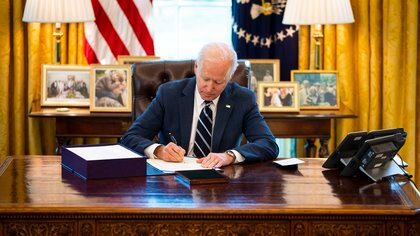 President Joe Biden signs the "American Rescue Plan" in the Oval Office of the White House in Washington on Thursday, March 11, 2021. The 365 days between America's panicked retreat from offices and schools and President Biden's speech on Thursday night, celebrating the prospect of a pandemicÕs end, may prove to be one of the most consequential years in American history. (Doug Mills/The New York Times)