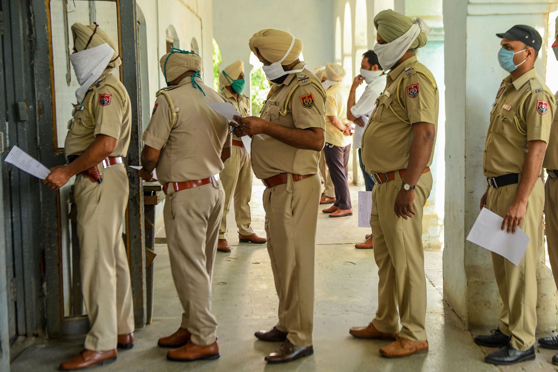 El personal de la Policía hace cola mientras espera a ser revisado por los trabajadores de la salud en un hospital en Amritsar el 22 de abril de 2020. (Foto de NARINDER NANU / AFP)