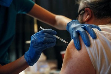 Un trabajador de la Autoridad Metropolita del Transporte recibe la vacuna de Pfizer contra el COVID-19, en el distrito de Manhattan, Nueva York (Reuters)
