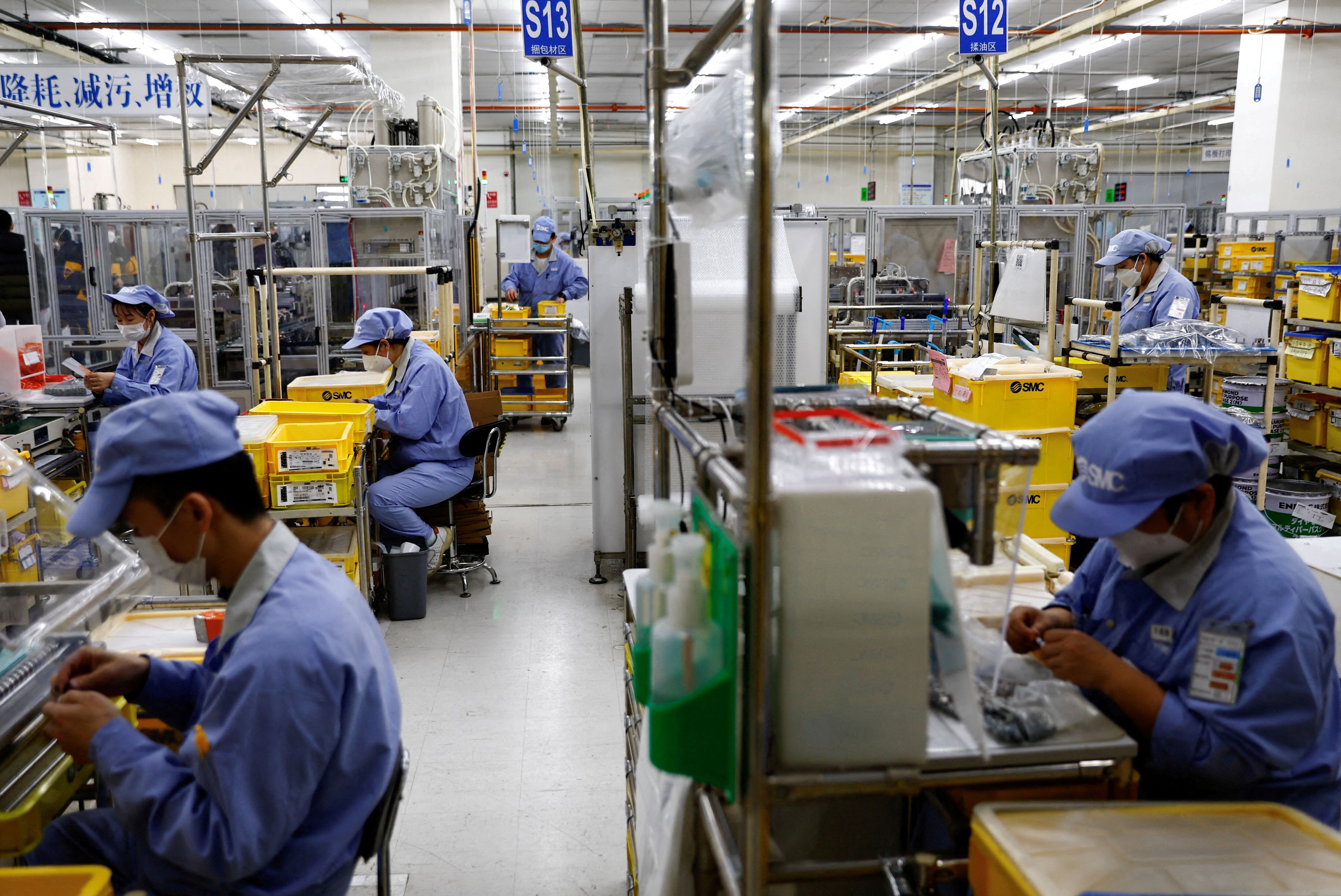 Trabajadores de una planta de Beijing (Reuters)