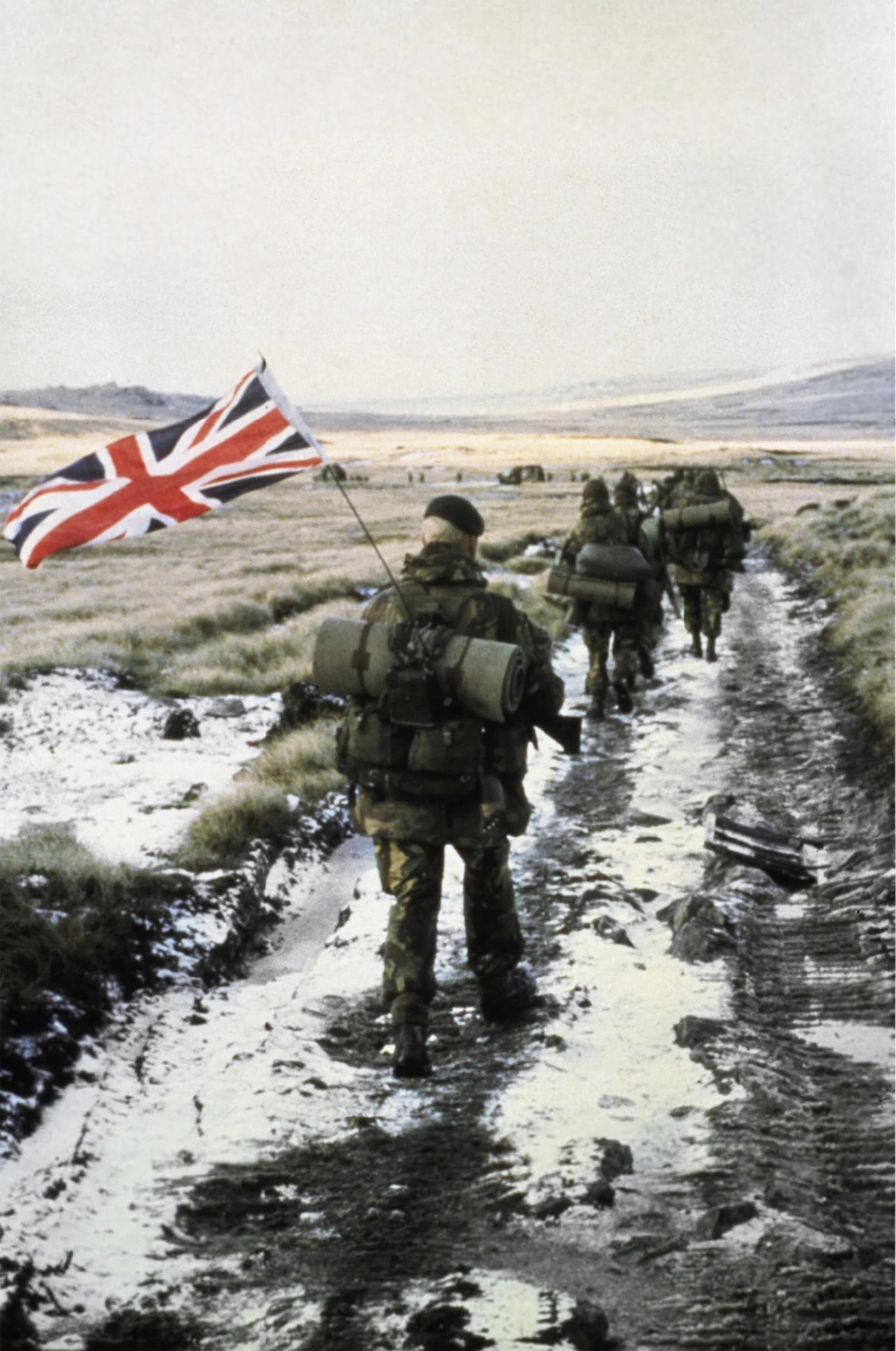 Grupos de los 40 y 45 Comandos de los Royal Marines marchan hacia Puerto Argentino  El Marine Peter Robinson lleva la bandera inglesa como símbolo de victoria (Imperial War Museums)