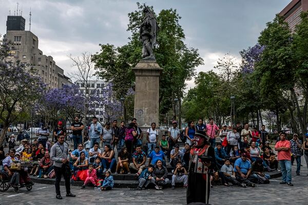 People gather to watch a street performer in Mexico City on March 17, 2020. The leaders of the region’s two largest nations — Mexico and Brazil — have largely dismissed the dangers of the coronavirus pandemic and have resisted calls for a lockdown. (Daniel Berehulak/The New York Times)