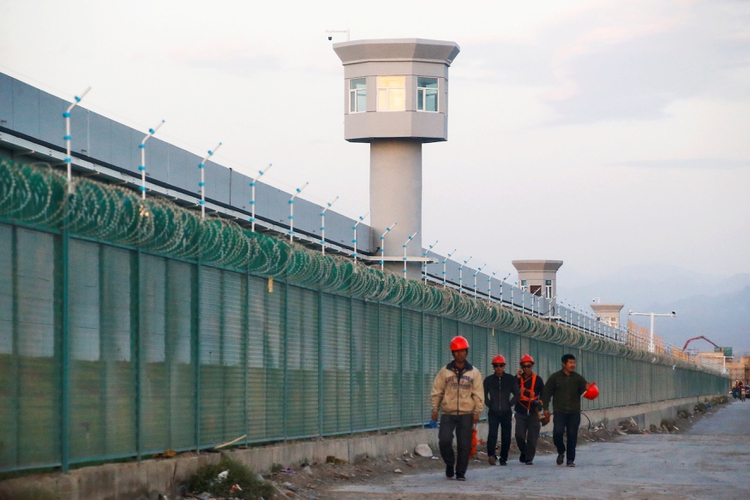 Trabajadores caminan por la valla perimetral de lo que oficialmente se conoce como centro de educación vocacional en Dabancheng, en la Región Autónoma Uigur de Xinjiang, China, el 4 de septiembre de 2018. Este centro, situado entre la capital regional Urumqi y el punto turístico Turpan, es uno de los más grandes conocidos y y todavía estaba en proceso de construcción y expansión en el momento en que se tomó la foto. (REUTERS / Thomas Peter)