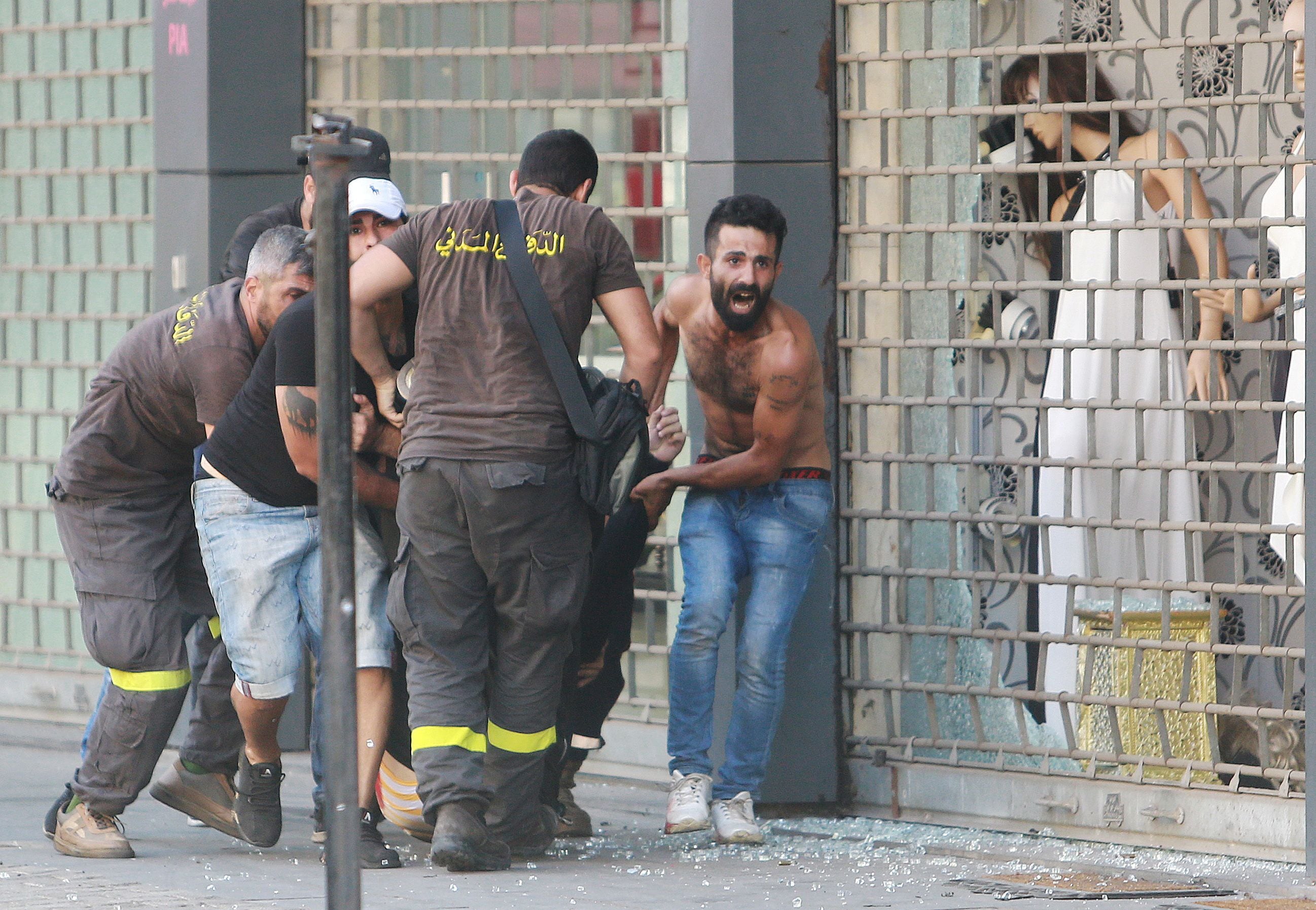 Personas evacuan a un herido tras un tiroteo en Beirut, Líbano, el 14 de octubre de 2021. REUTERS/Aziz Taher 
