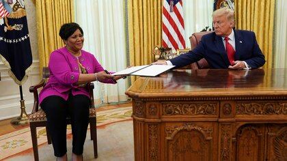 Alice Johnson, who received a life sentence for a first-time drug offense, receives a pardon from U.S. President Donald Trump in the Oval Office of the White House in Washington, U.S., August 28, 2020.  REUTERS/Kevin Lamarque