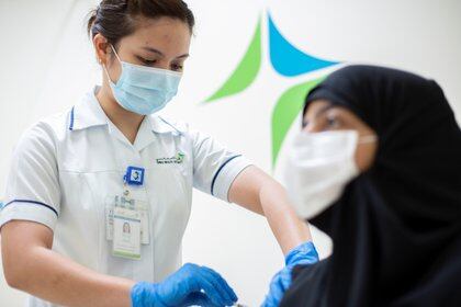 Un trabajador médico inyecta una dosis de una vacuna contra la enfermedad coronavirus (COVID-19) a una mujer, en Dubai, Emiratos Árabes Unidos, el 23 de diciembre,