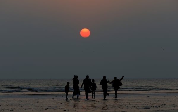Una familia en la playa de Clifton, en Karachi, Pakistán, en la última puesta de sol de 2019