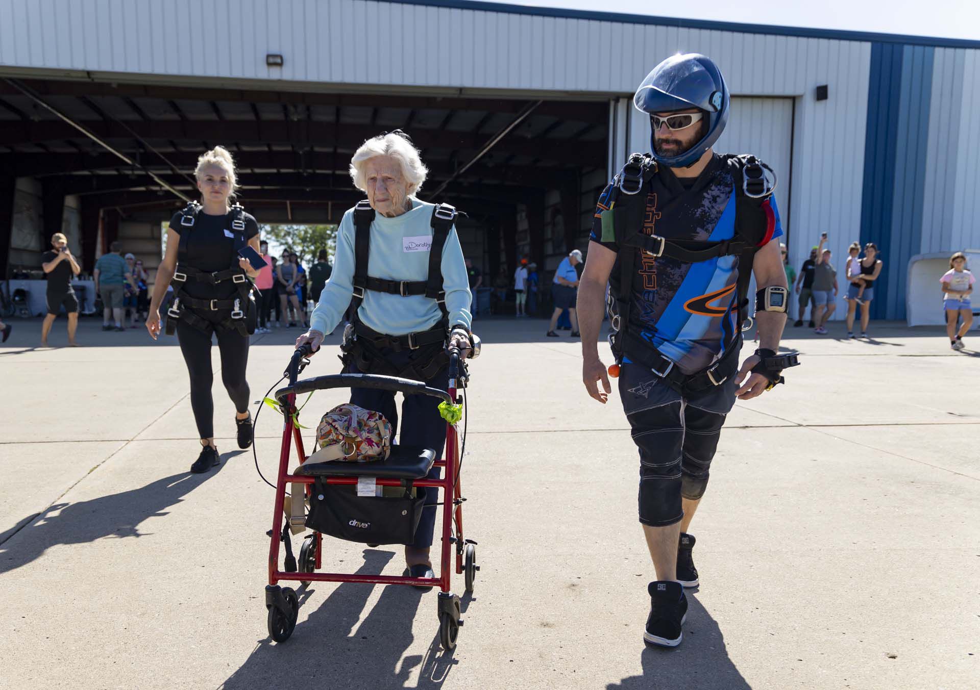 Dorothy Hoffner camina hacia el aeroplano junto al instructor Derek Baxter. Se convirtió en la persona más anciana en haber saltado en paracaídas (Brian Cassella/Chicago Tribune via AP)