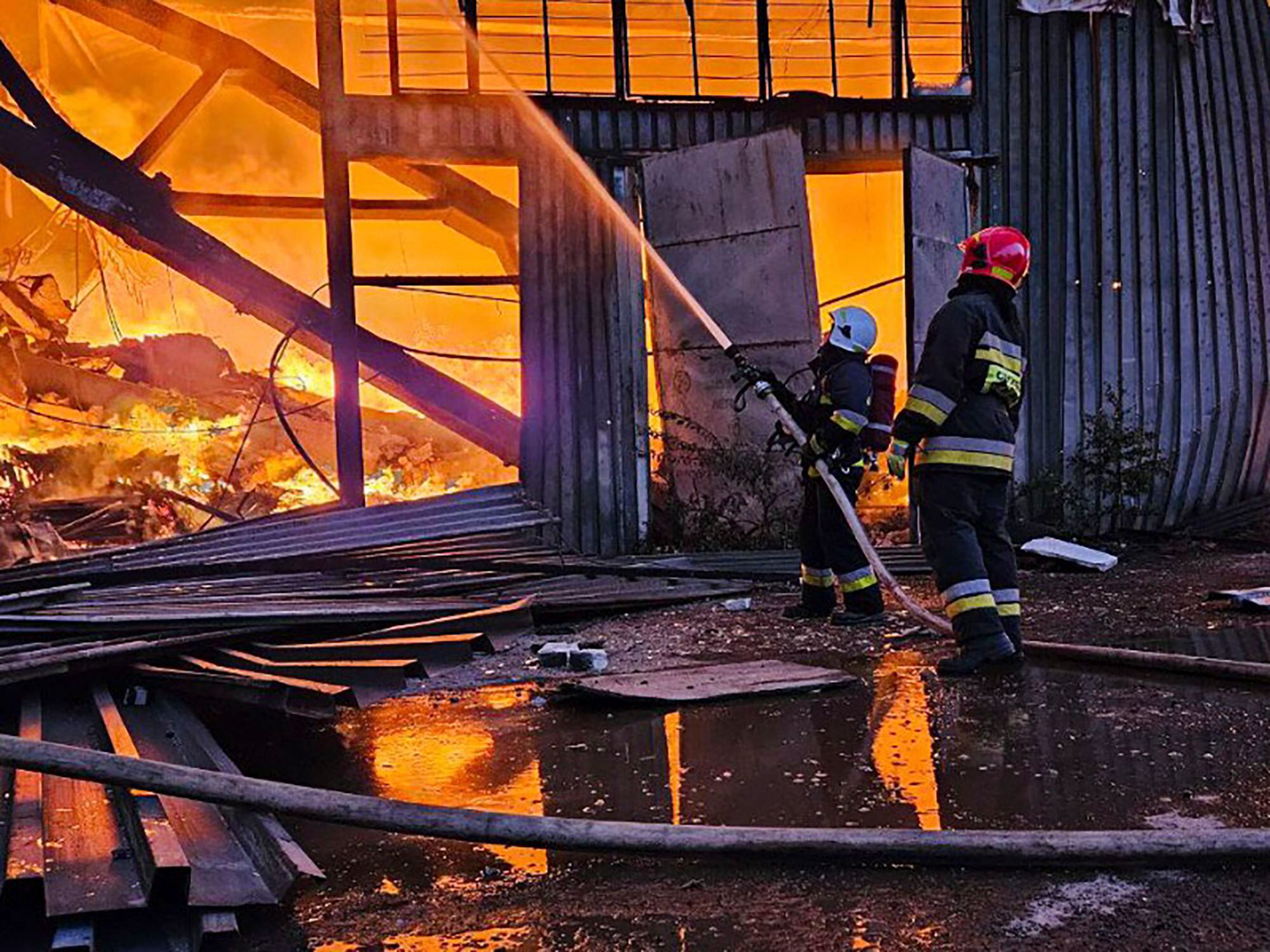 Bomberos tratan de sofocar un incendio causado por un ataque ruso, en Leópolis (Servicio de Emergencias de Ucrania vía AP)