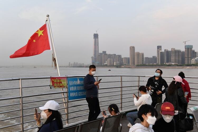 Pasajeros con mascarillas a bordo de un ferry por el río Yangtsé después de que se levantaran las restricciones de viaje para salir de Wuhan, la capital de la provincia de Hubei y el epicentro del brote del nuevo coronavirus en China (Reuters)