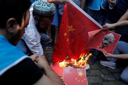 Miembros de la etnia musulmana uigur queman una bandera china en protesta por las políticas del Gobierno hacia las minorías. FOTO DE ARCHIVO.  Octubre, 2019. REUTERS/Huseyin Aldemir