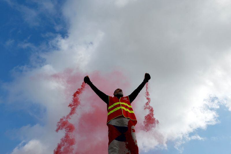 Un manifestante, con un chaleco del sindicato CGT, sostiene bengalas rojas mientras asiste a una manifestación durante el noveno día de huelgas y protestas a nivel nacional contra la reforma de las pensiones del Gobierno francés, en Niza, Francia, 23 de marzo de 2023. REUTERS/Eric Gaillard