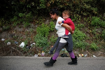Una mujer hondureña carga a su bebé en el medio de la nueva caravana migrante con destino a los Estados Unidos. REUTERS/Luis Echeverria