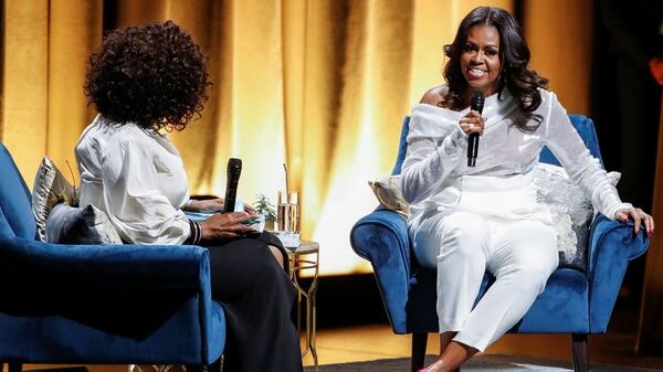 Oprah Winfrey habla con la ex primera dama Michelle Obama cuando comienza su gira de libro convirtiéndose con una parada en el United Center en Chicago, Illinois (REUTERS/Kamil Krzaczynski)