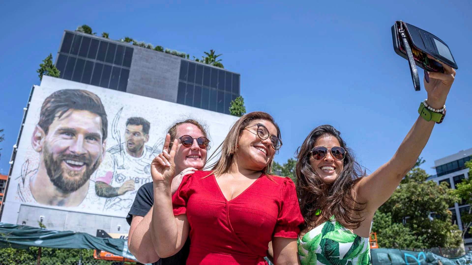 Tres aficionadas fueron registradas este lunes, 10 de julio, al tomarse una fotografía frente un mural del futbolista argentino Lionel Messi, nuevo refuerzo del equipo Inter Miami de la MLS, hecho por el artista Maximiliano Bagnasco, en Wynwood (Florida, EE.UU.). EFE/Cristóbal Herrera
