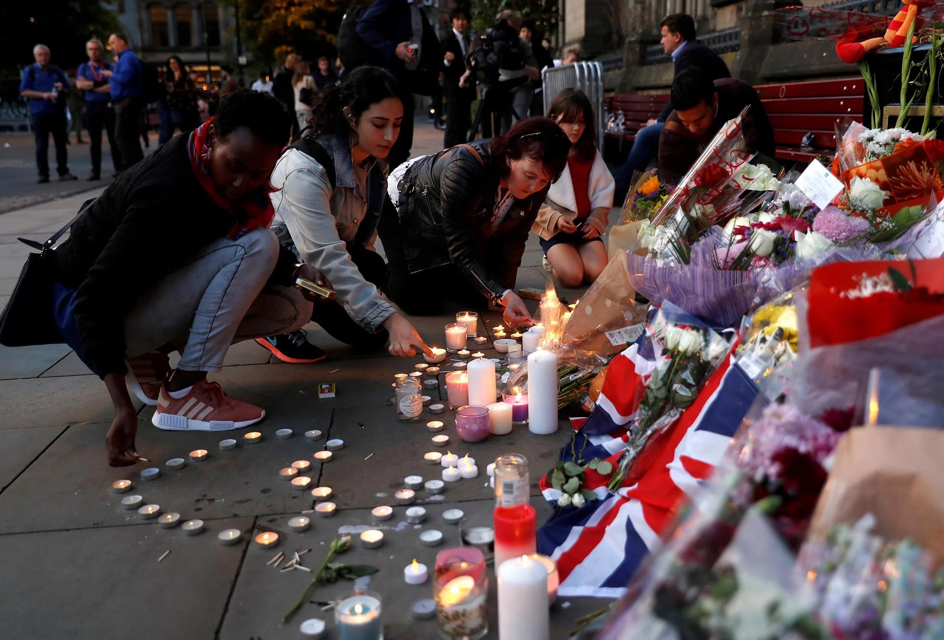 Unas mujeres encienden velas por las víctimas del atentado en el Arena Manchester (Reuters)