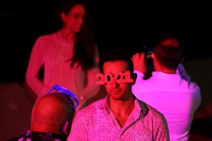 Un hombre con anteojos con forma de 2021 aguarda que comiencen los fuegos artificiales en el puerto de Sídney, Australia (Reuters/ Loren Elliott)