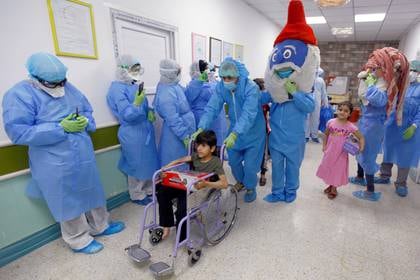 Médicos y enfermeras celebran que un chico que desarrolló COVID-19 en forma grave logró recuperarse en el hospital de Najaf, Iraq . REUTERS/Alaa al-Marjani