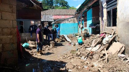 Personas caminan por una calle afectada por lluvias e inundaciones en el sector La Palmita, en Rubio, estado Táchira (EFE/JOHNNY PARRA)