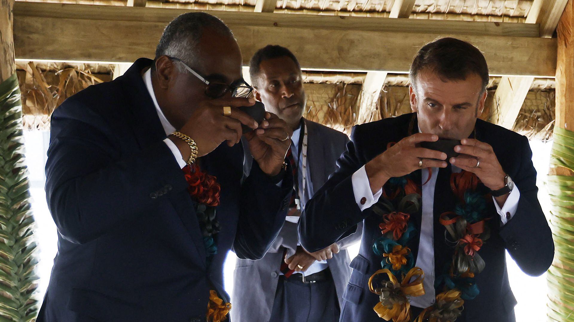 Kalsakau y Macron beben kava durante una ceremonia tradicional de bienvenida (Ludovic MARIN / AFP)