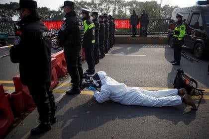 El camarógrafo de Reuters Martin Pollard lleva un traje protector mientras filma en el puente del río Yangtse en Jiujiang, provincia de Jiangxi, China