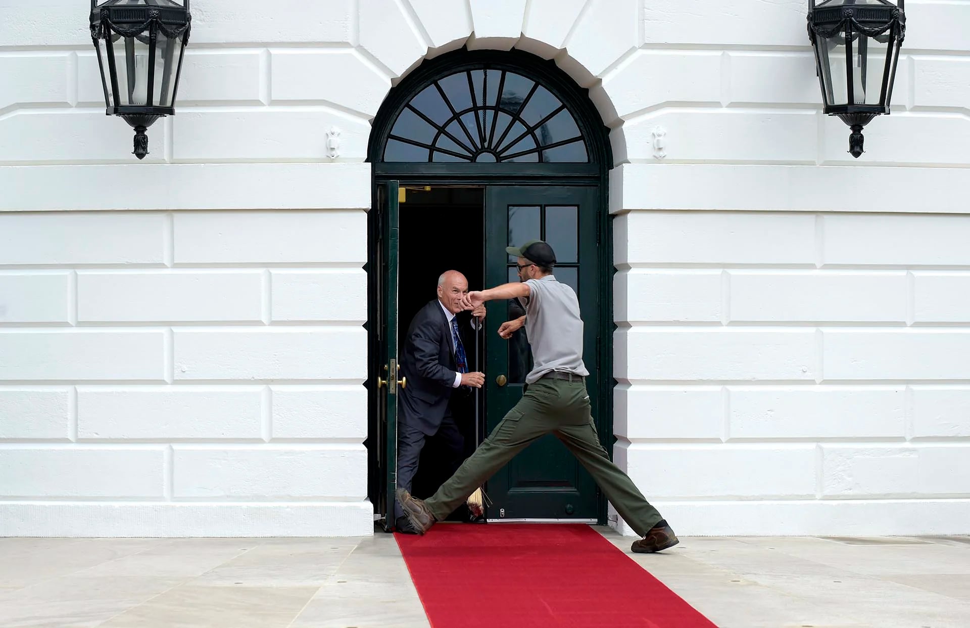 Un trabajador salta por encima de la alfombra roja en la Casa Blanca, antes del encuentro entre el presidente de Estados Unidos, Donald Trump, y el máximo mandatario de Panamá, Juan Carlos Varela, en Washington, Estados Unidos