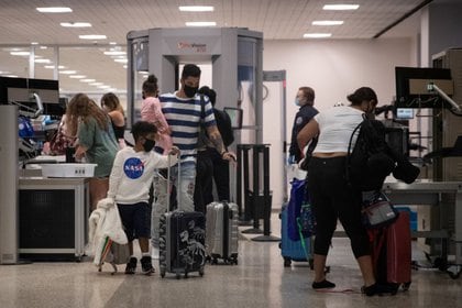 FOTO DE ARCHIVO: Una familia usa mascarillas al pasar la seguridad en la Terminal A del Aeropuerto Intercontinental George Bush en medio del brote de la enfermedad coronavirus (COVID-19) en Houston, Texas, Estados Unidos.  21 de julio de 2020. REUTERS/Adrees Latif/