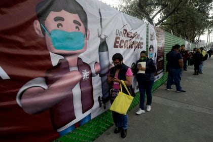 People queue to borrow or refill oxygen tanks from a government program for their COVID-19 infected relatives in Ecatepec, Mexico State, Mexico on January 13, 2021. - After the increase in COVID-19 cases in central Mexico, there is a shortage in medicinal gas. (Photo by PEDRO PARDO / AFP)