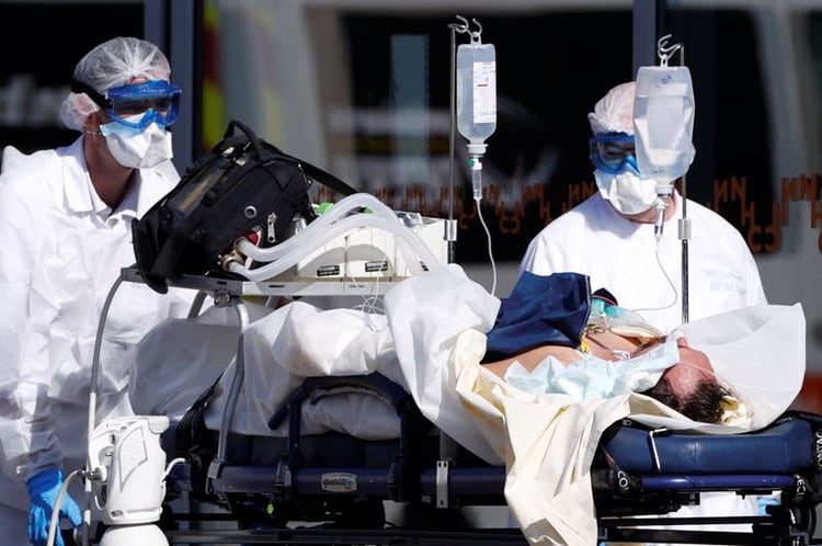 Un equipo de rescate francés con trajes protectores lleva a un paciente al hospital de la Universidad de Estrasburgo. 16 de marzo de 2020. REUTERS/Christian Hartmann