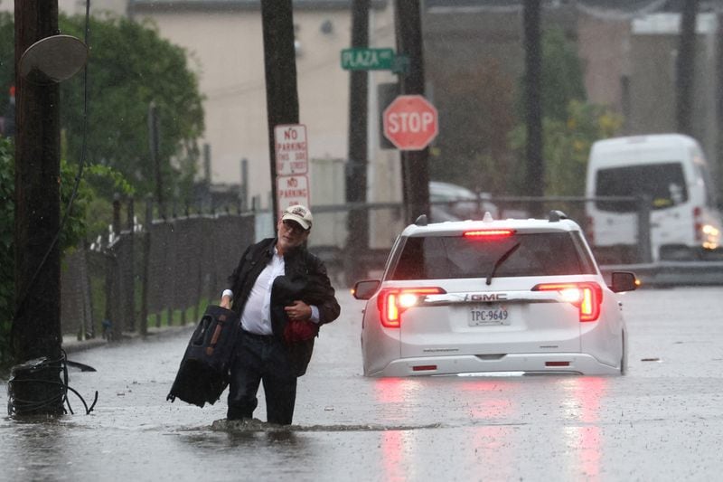 Un hombre carga sus pertenencias mientras abandona su vehículo que se detuvo en las inundaciones durante una fuerte tormenta en el suburbio de Mamaroneck en la ciudad de Nueva York en el condado de Westchester, Nueva York, EEUU, el 29 de septiembre de 2023.REUTERS/Mike Segar
