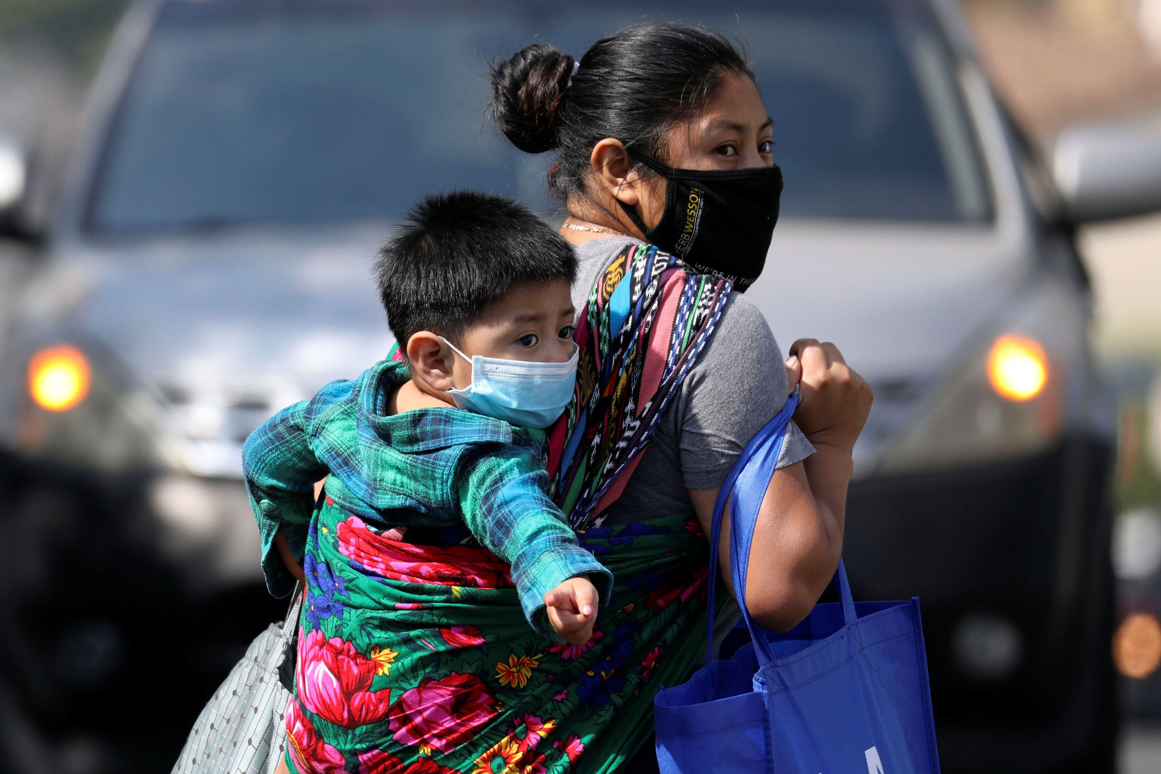 Una mujer y su niño llevan mascarillas en Los Ángeles